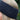 A close up of a blonde lady's head outdoors wearing a slate grey knitted headband.